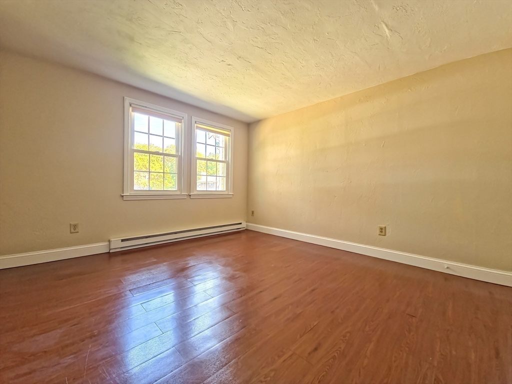 300 Falmouth Road, Unit 18E Mashpee, MA 02649 - Photo 18 of 33 a view of an empty room with wooden floor and a window