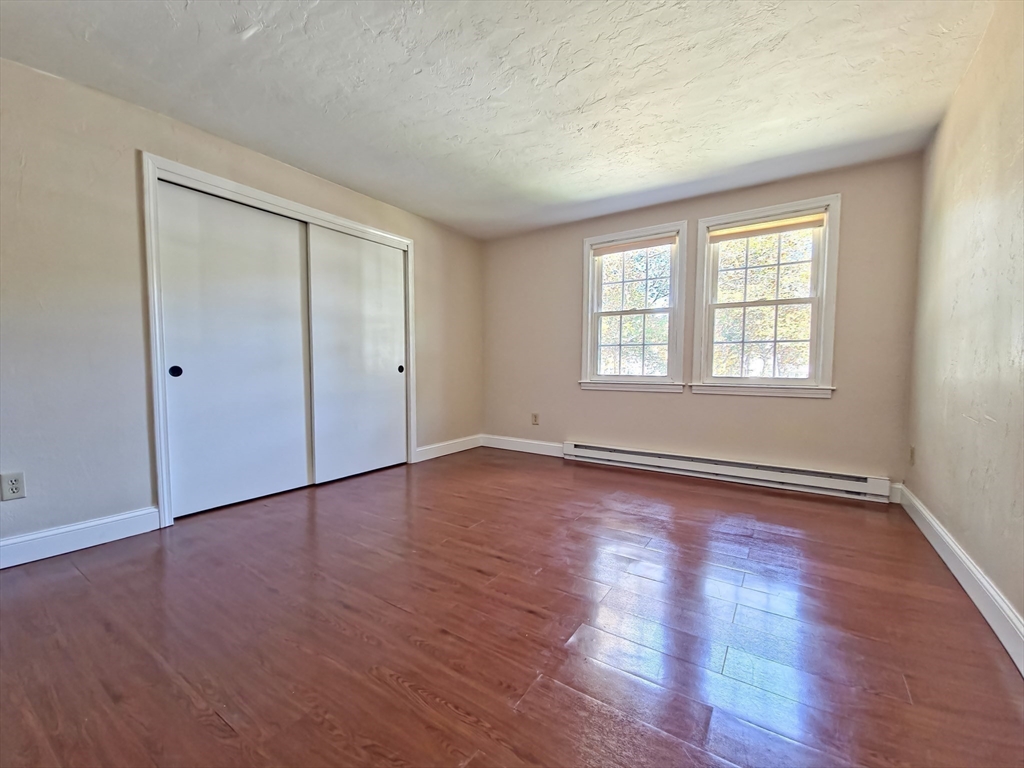 300 Falmouth Road, Unit 18E Mashpee, MA 02649 - Photo 19 of 33 an empty room with wooden floor and windows