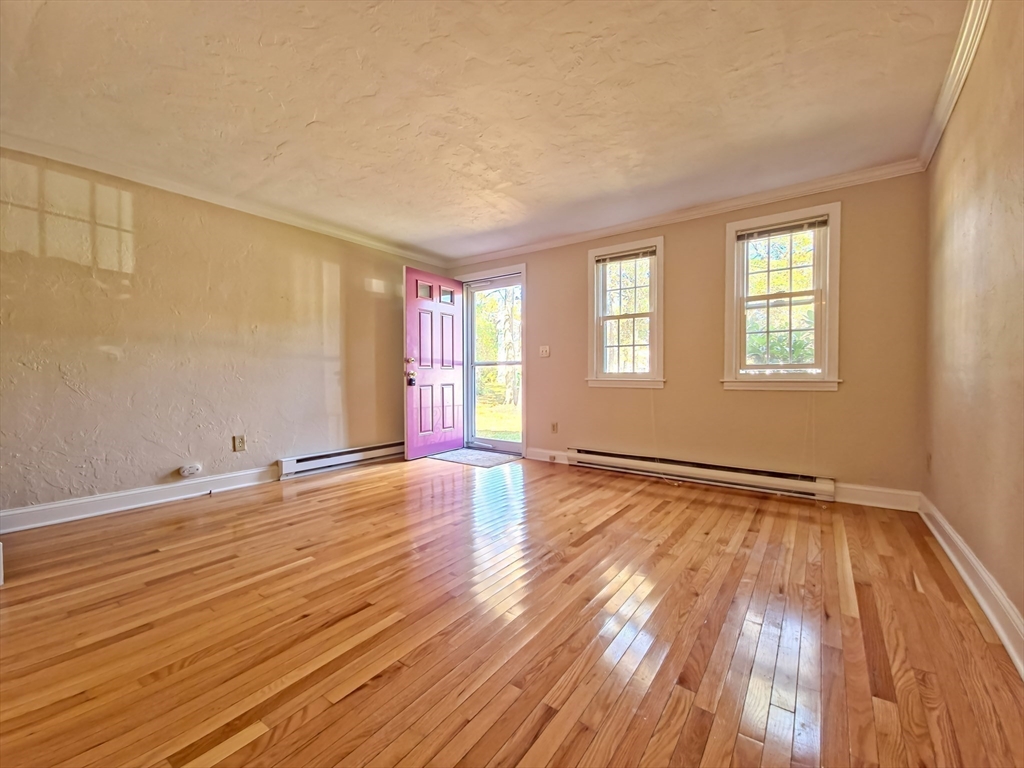 300 Falmouth Road, Unit 18E Mashpee, MA 02649 - Photo 2 of 33 a view of an empty room with wooden floor and a window