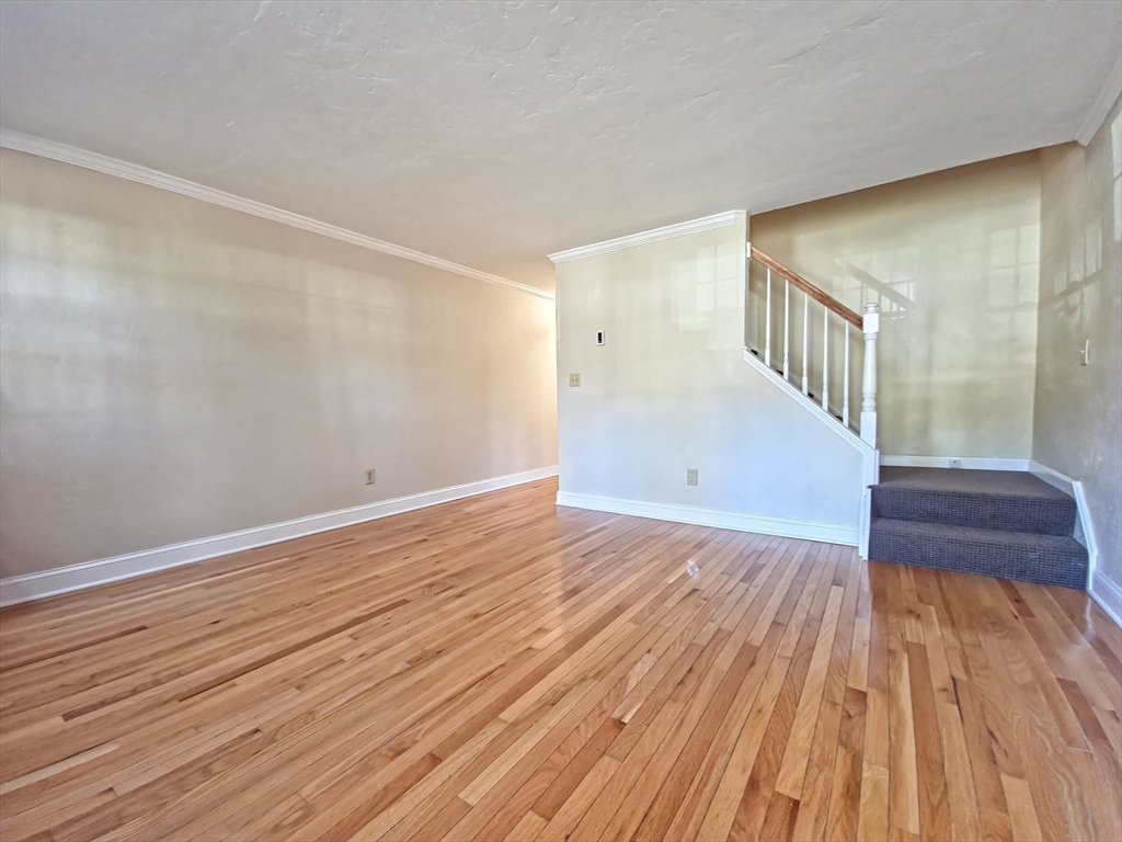 300 Falmouth Road, Unit 18E Mashpee, MA 02649 - Photo 4 of 33 a view of an empty room with wooden floor and a window