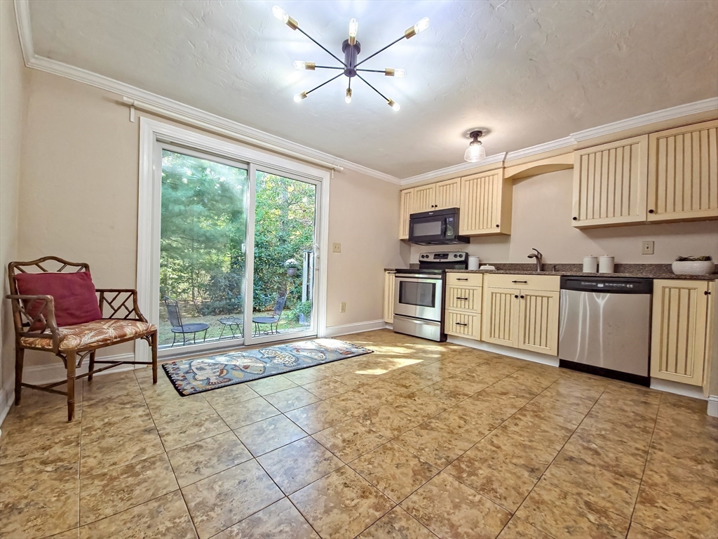300 Falmouth Road, Unit 18E Mashpee, MA 02649 - Photo 7 of 33 a kitchen with stainless steel appliances granite countertop a stove top oven a sink a dining table and chairs