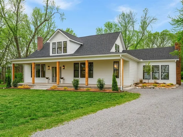 front view of a house with a yard and sitting area