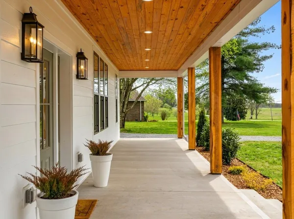 a view of a porch with furniture and garden