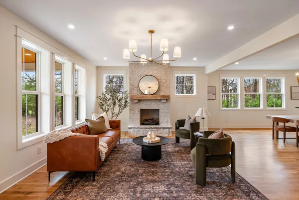 a living room with fireplace furniture and a large window