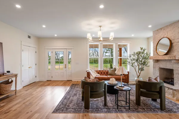 a living room with furniture a chandelier and a fireplace