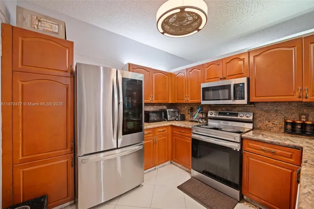 a kitchen with stainless steel appliances granite countertop a refrigerator stove and microwave