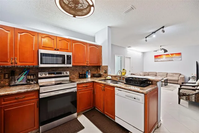 a kitchen with stainless steel appliances a stove sink microwave and cabinets