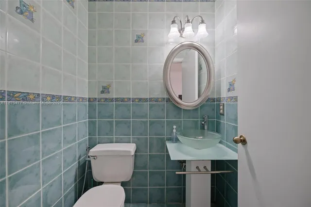 a bathroom with a toilet a sink and mirror