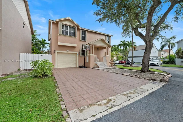a front view of a house with a yard and a garage