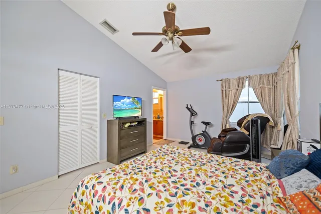 a bedroom with a bed and a flat tv screen on dresser