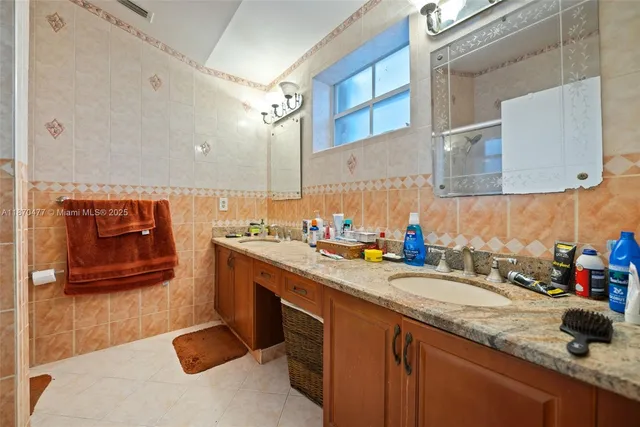 a kitchen with stainless steel appliances granite countertop a sink a stove and a wooden cabinets