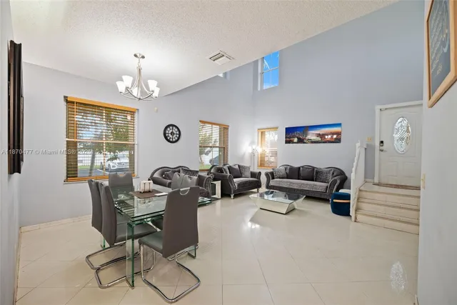 a living room with furniture chandelier and a window