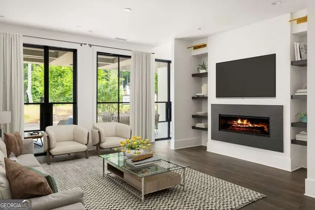 a living room with furniture a flat screen tv and a fireplace