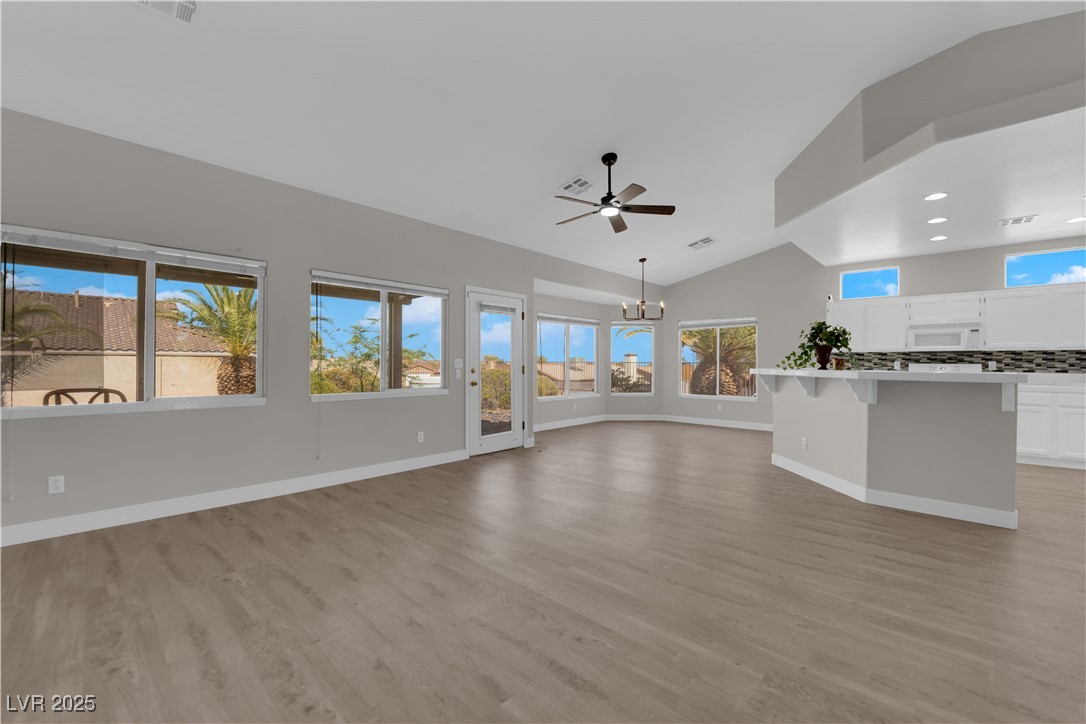 650 West Victory Road Henderson, NV 89015 - Photo 4 of 35 Unfurnished living room with vaulted ceiling, light wood finished floors, a chandelier, recessed lighting, and ceiling fan