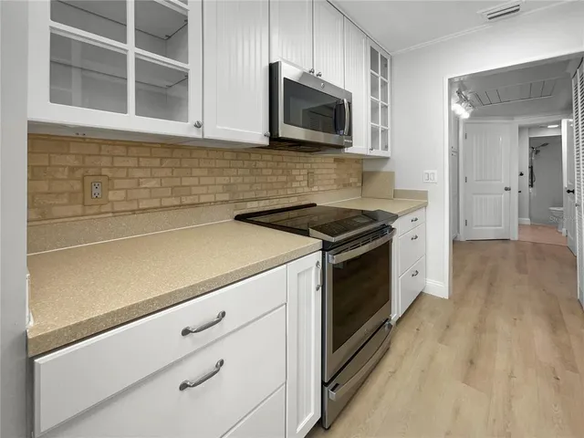 a kitchen with stainless steel appliances a stove microwave and cabinets