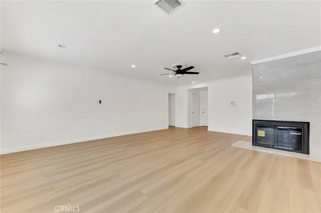 an empty room with a fireplace and cabinet