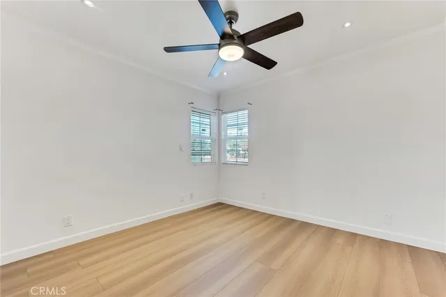 an empty room with a window and a fan