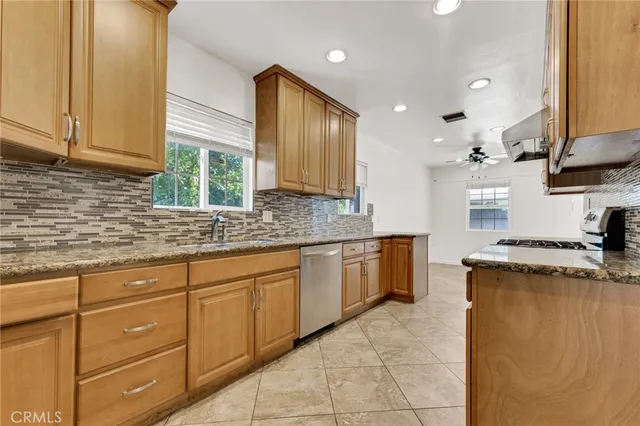 a kitchen with granite countertop cabinets stainless steel appliances a sink and a counter top space