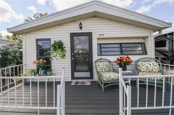 a front view of a house with outdoor seating and potted plants