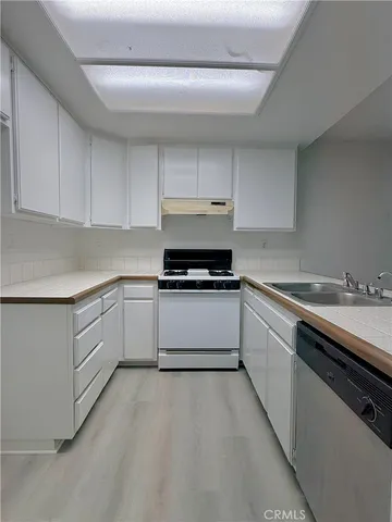 a kitchen with granite countertop white cabinets and white appliances