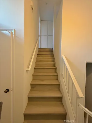 a view of staircase with wooden floor and white walls