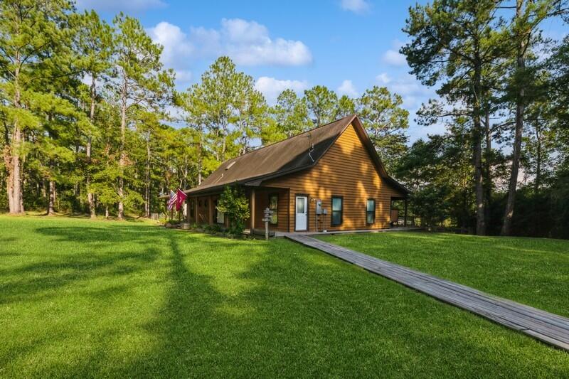 5540 Old River Road Baker, FL 32531 - Photo 2 of 37 a front view of a house with a yard and trees