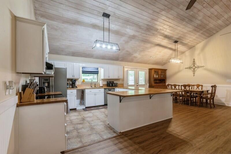 5540 Old River Road Baker, FL 32531 - Photo 7 of 37 a kitchen with stainless steel appliances kitchen island granite countertop a table chairs sink and cabinets