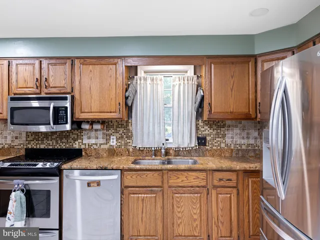 a kitchen with stainless steel appliances granite countertop a refrigerator and a sink