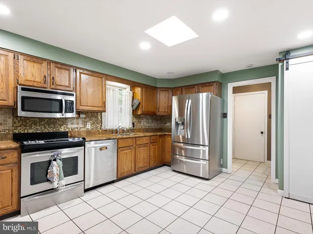 a kitchen with stainless steel appliances granite countertop a refrigerator and a stove top oven