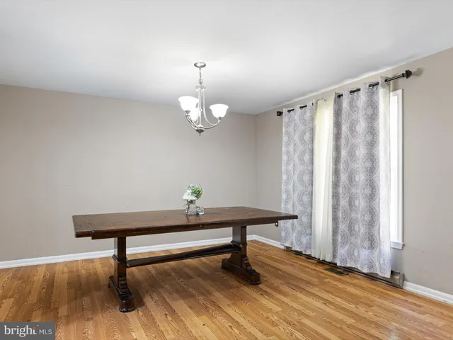 a view of a room with wooden floor table and chairs