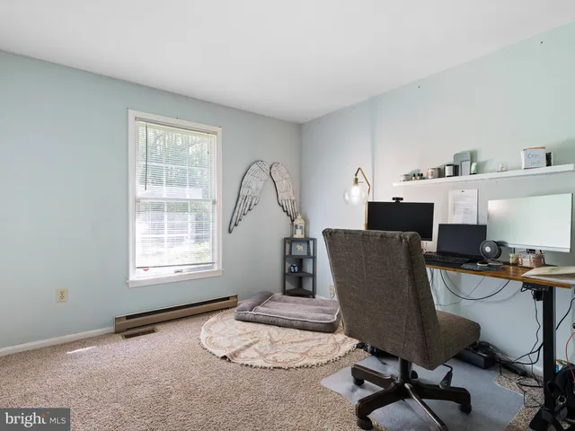 a view of a workspace with furniture and a window