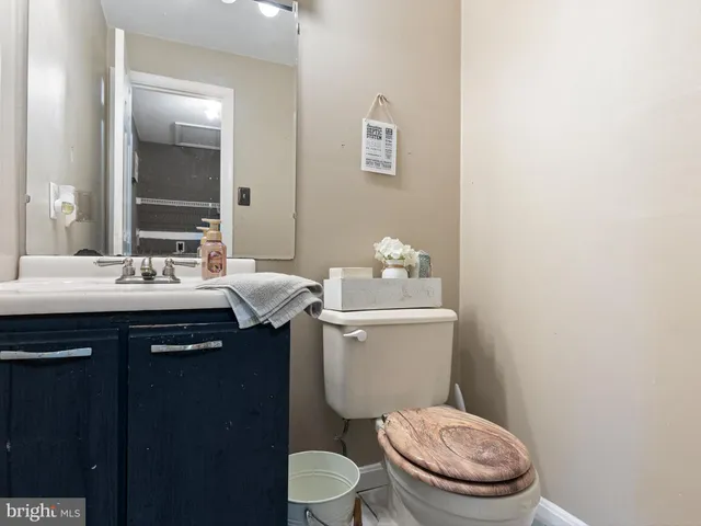 a bathroom with a granite countertop toilet sink and mirror