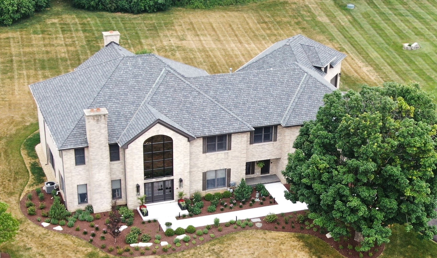 a front view of a house with a yard and lake view
