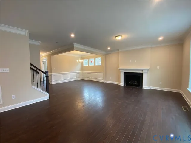 an empty room with wooden floor and fireplace