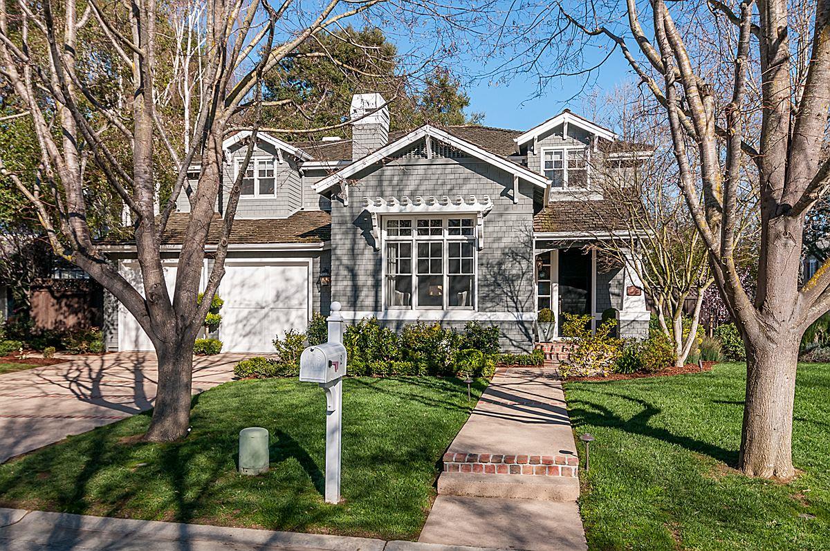 a front view of a house with a yard and potted plants