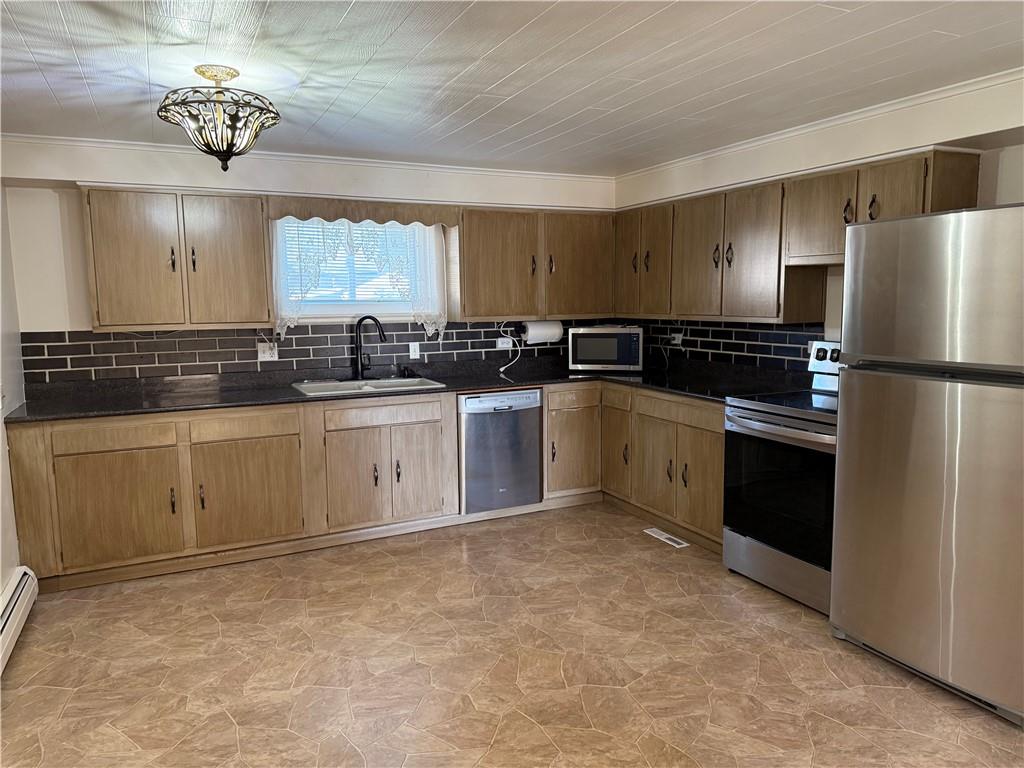 243 South Sycamore Street Mount Pleasant, PA 15666 - Photo 6 of 27 a kitchen with a sink stainless steel appliances cabinets and a window