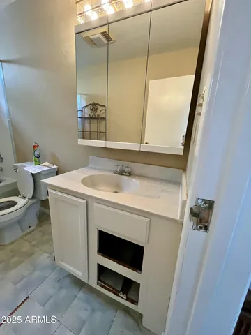 a bathroom with a sink a toilet and a mirror