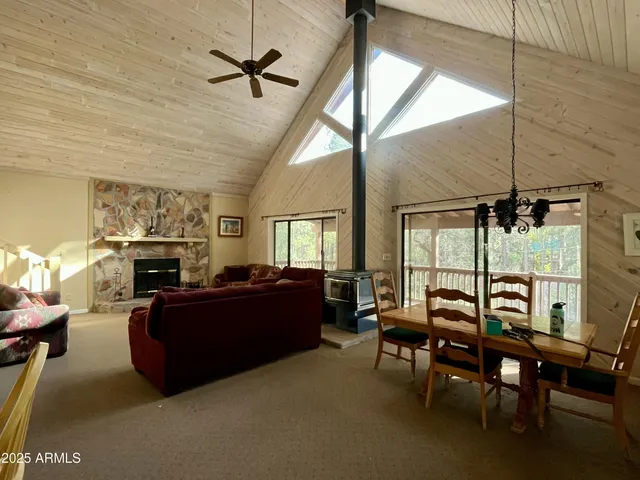 a living room with furniture a fireplace and a floor to ceiling window