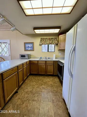 a large kitchen with stainless steel appliances granite countertop a sink stove and refrigerator