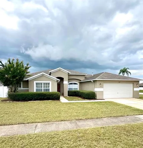 a front view of a house with a garden and lake view