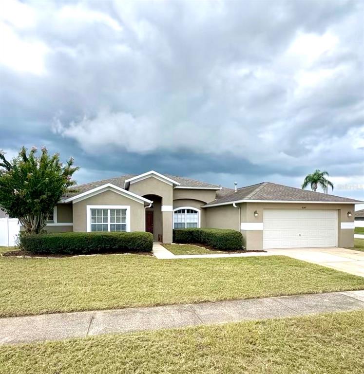 a front view of a house with a garden and lake view