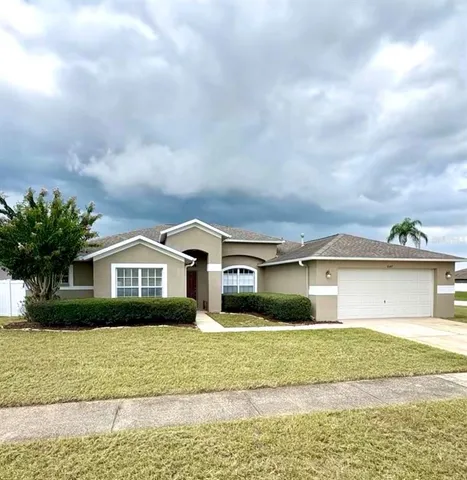 a front view of a house with a garden and lake view