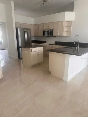 a kitchen with stainless steel appliances a sink stove refrigerator and cabinets
