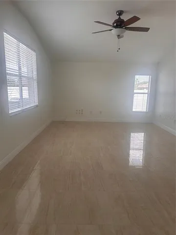 an empty room with windows and fan