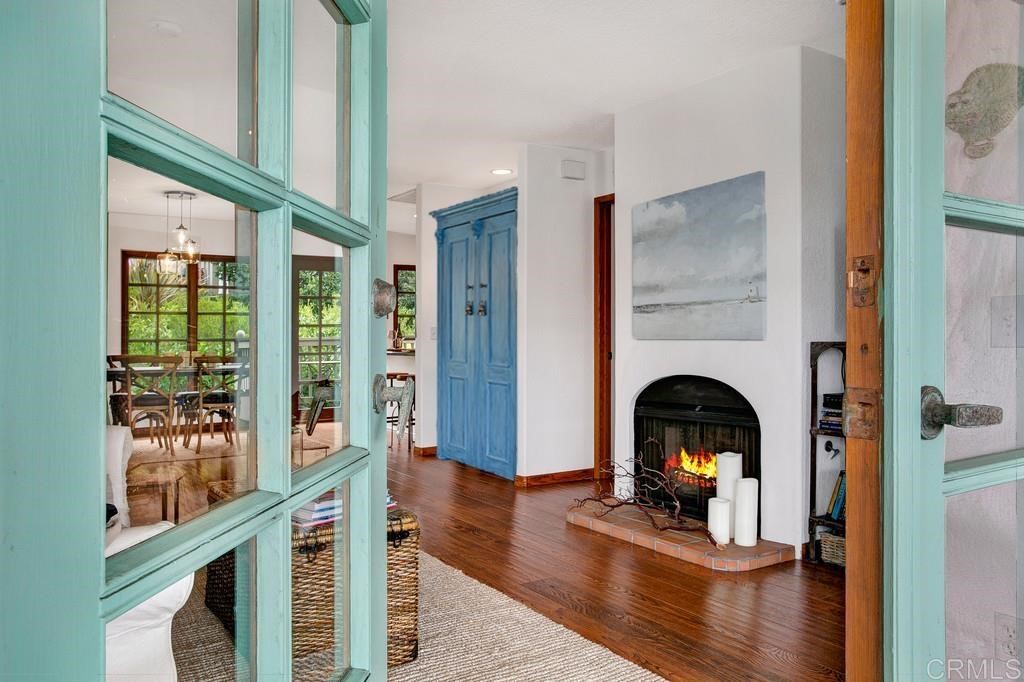 a living room with fireplace furniture wooden floor and a large window