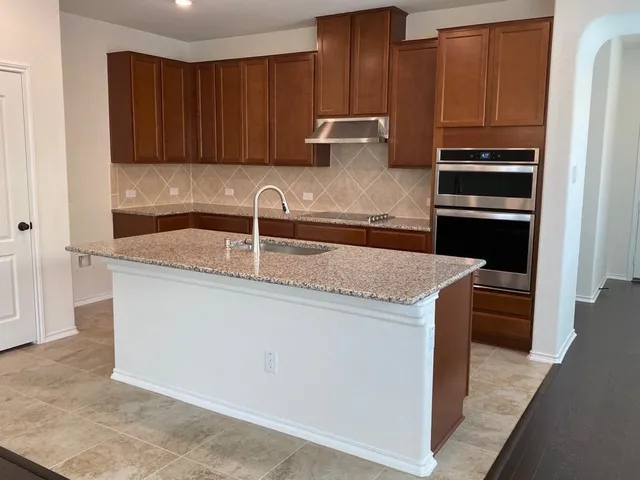 a kitchen with granite countertop a stove and a refrigerator