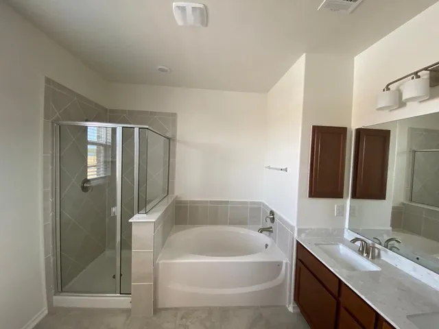 a bathroom with a bathtub a shower a sink and mirror