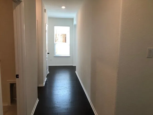 a view of a hallway with wooden floor