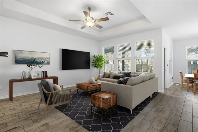 a living room with furniture a flat screen tv and a large window