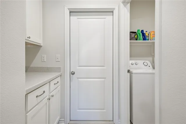 a utility room with cabinets washer and dryer